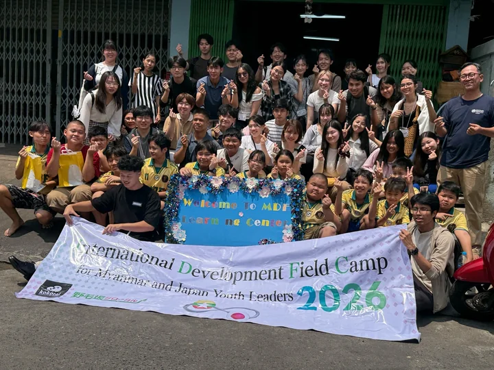 An evening group photo of IDFC2026 participants with the conference banner