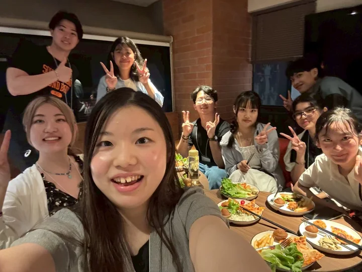 IDFC2026 participants smiling for a selfie around a meal table